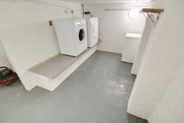 Separate laundry room in basement with washer, dryer & freezer